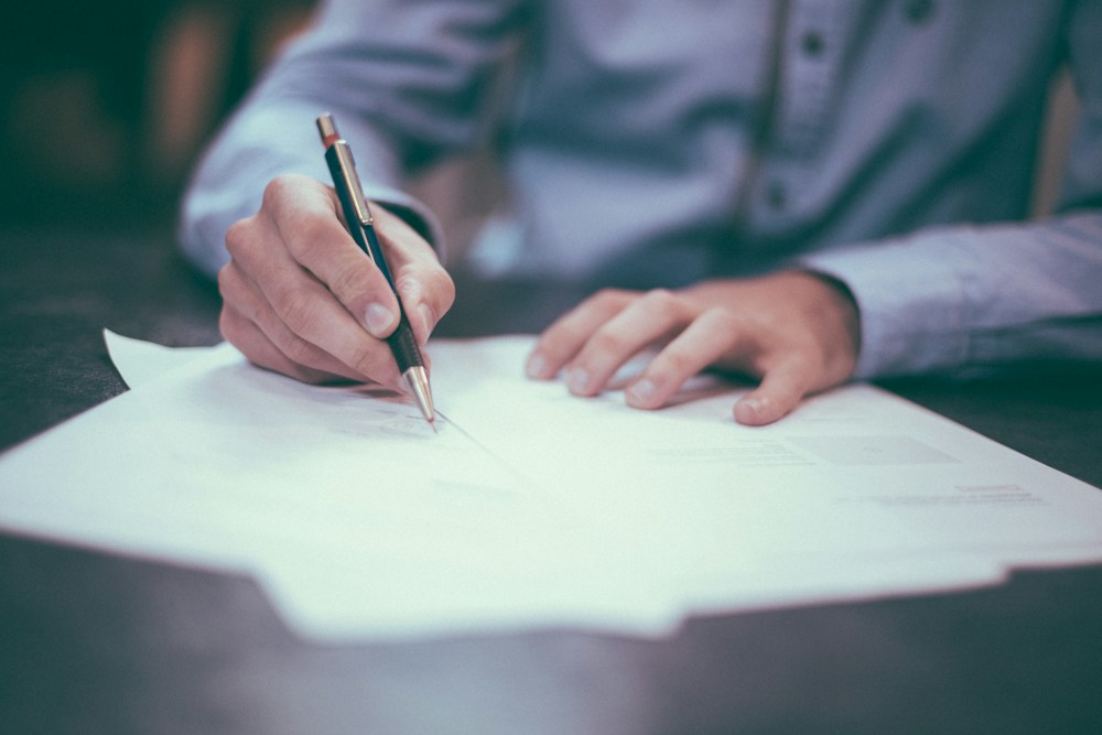 A person completing business documents and paperwork